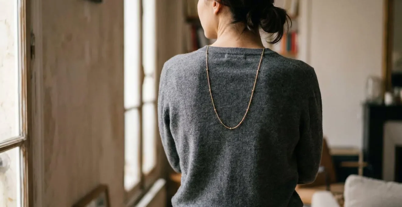 Chaîne de dos dorée sur pull cachemire vue de trois quarts arrière