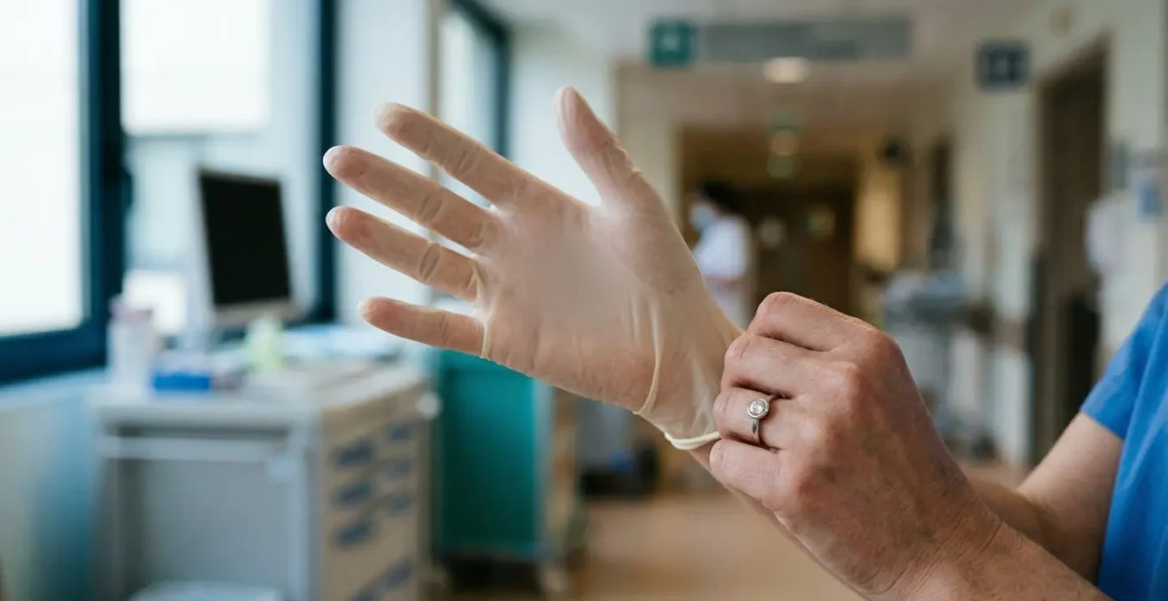 Mains d'une professionnelle de santé portant des gants en latex avec une bague serti clos, montrant l'absence d'accrochage